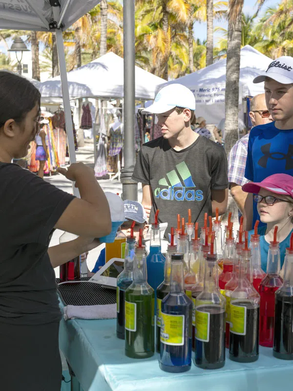 Shave ice station with colorful syrups serving a line of guests